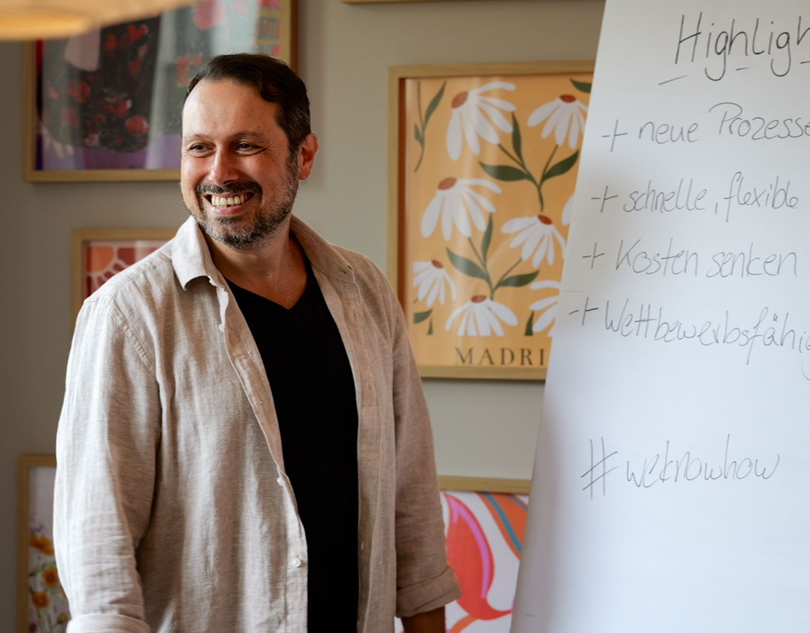 Zwei Männer arbeiten fröhlich zusammen und haben eine Mindmap auf einem Whiteboard abgebildet